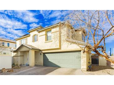 Two-story home featuring an attached garage, neutral stucco, covered entryway, and well-kept landscaping at 6356 Blue Twilight Ct, Las Vegas, NV 89108