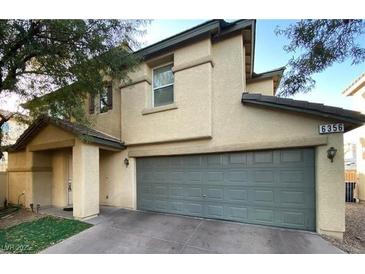 Two-story house with gray garage door and tan exterior at 6356 Blue Twilight Ct, Las Vegas, NV 89108