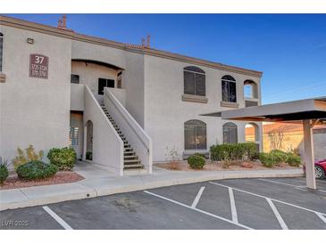 Condo building featuring stucco facade, covered parking, and neatly landscaped front yard at 700 Carnegie St # 3711, Henderson, NV 89052