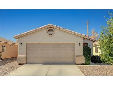 Beige single-story home with an attached two-car garage and concrete driveway at 2717 El Milagro St, Las Vegas, NV 89108