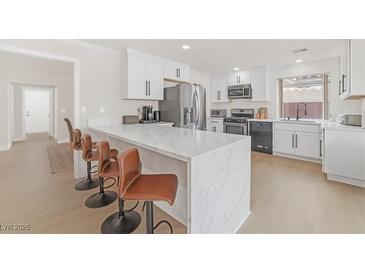 Modern kitchen with white cabinets, stainless steel appliances, and a large island at 2928 Cape Verde Ln, Las Vegas, NV 89128
