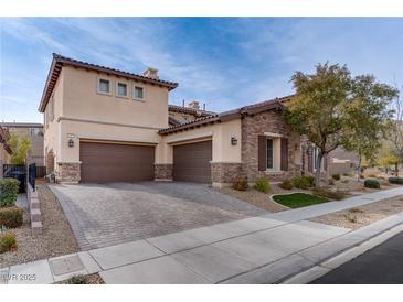 Two-story house with stone and stucco exterior, brown garage doors, and landscaped yard at 37 Carolina Cherry Dr, Las Vegas, NV 89141