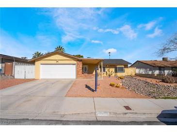 Single-story home with a two car garage, front lawn with desert landscaping, and a driveway at 4110 Oakhill Ave, Las Vegas, NV 89121