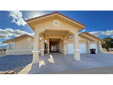 Inviting home exterior showcasing a covered drive, well-maintained stucco, and a two-car garage at 1771 Labrador St, Pahrump, NV 89048