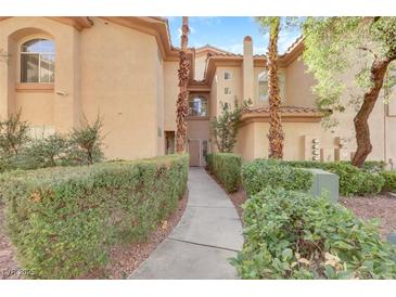 Inviting stucco townhouse with a well-maintained, hedge-lined walkway to the front door at 2050 W Warm Springs Rd # 3322, Henderson, NV 89014