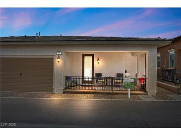 View of home featuring a 2-car garage and charming front porch with seating area at 723 Orange Plume Walk # 0, Henderson, NV 89011