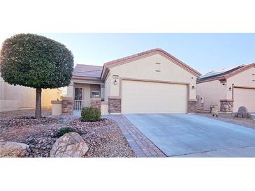 Charming single-story home featuring a well-maintained landscaped front yard and a two-car garage at 7405 Petrel St, North Las Vegas, NV 89084