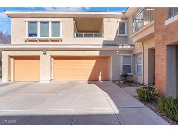 Spacious condo featuring two-car garage, a balcony, and manicured landscaping at 830 Cozette Ct # 102, Las Vegas, NV 89144