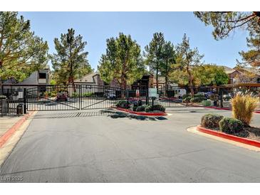 Gated community entrance featuring mature trees, landscaping, and secure access for residents at 555 E Silverado Ranch Blvd # 2086, Las Vegas, NV 89183
