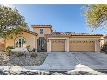 Tan two-story house with three-car garage and landscaped yard at 8109 Mountain Forest Ct, Las Vegas, NV 89129