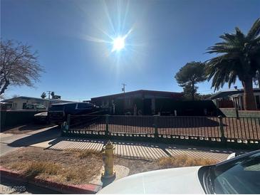 Modest home with a desert landscape, black iron fence, and plenty of parking space at 2408 Canosa Ave, Las Vegas, NV 89104