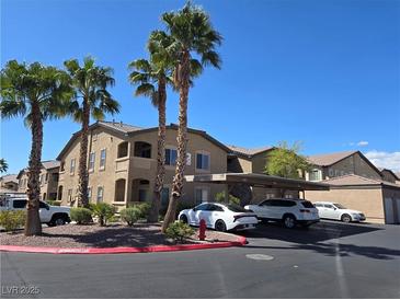 Exterior view of condo building with palm trees, covered parking, and well-maintained landscaping at 8985 S Durango Dr # 2062, Las Vegas, NV 89113