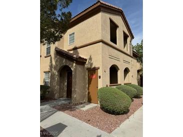 Two-story building exterior with Spanish-style architecture and landscaping at 10290 Gilmore Canyon Ct # 103, Las Vegas, NV 89129