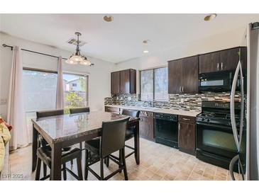 Eat in kitchen featuring dark cabinetry, stainless steel appliances, decorative tile backsplash, and a tile floor at 2905 Vigilante Ct, North Las Vegas, NV 89081