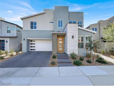 Modern two-story home featuring a brick driveway, a two-car garage, and professionally landscaped front yard at 3197 Vittoria Ave, Henderson, NV 89044