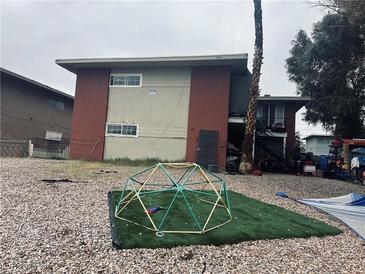 A two-story home with a brick and stucco exterior and a play structure in the yard at 3381 Brussels St, Las Vegas, NV 89169