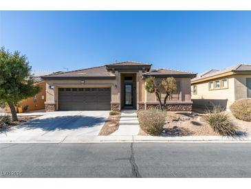 Charming single-story home featuring a well-manicured front yard and a two-car garage at 5805 Hannah Brook St, North Las Vegas, NV 89081