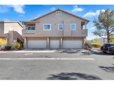 Contemporary townhome with three garage spaces, tan exterior, balconies, and minimal landscaping at 2152 Quarry Ridge St # 106, Las Vegas, NV 89117