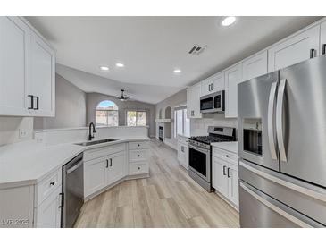 A bright, modern kitchen featuring stainless steel appliances and white cabinets at 1106 Emerald Stone Ave, North Las Vegas, NV 89081