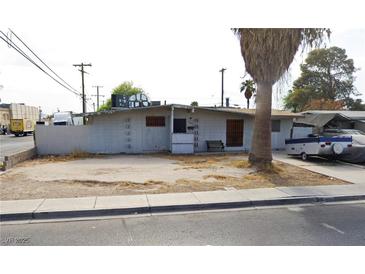 Exterior view of a single-story house with block wall and a desert style front yard with some trees at 1836 Mcdaniel St, North Las Vegas, NV 89030