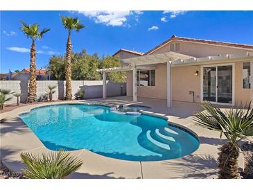 Inviting backyard pool with a spa, covered patio and lush landscaping, perfect for relaxation and entertainment at 283 Fancrest St, Henderson, NV 89052