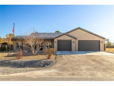 Charming single-story home featuring a spacious driveway and a two-car garage at 3101 S Spy Glass Ave, Pahrump, NV 89048