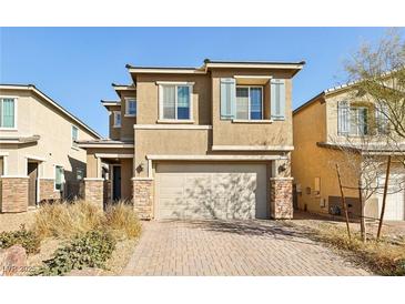 Two-story home with a two car garage, stone accents, blue shutters, and a paved driveway at 3770 S Rosy Carina Pl, Henderson, NV 89052