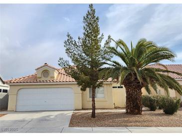 Charming single-story home featuring a two-car garage, complemented by mature palm and pine trees at 4610 Cannon Beach St, Las Vegas, NV 89122