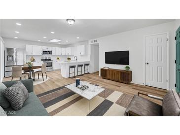 Bright living room with wood floors, stylish furniture, and a modern TV stand at 6520 Evergreen Ave, Las Vegas, NV 89107