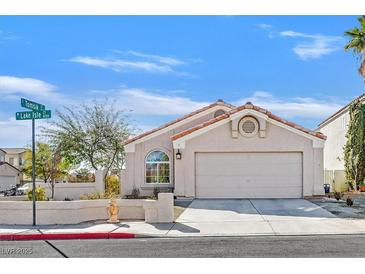 Charming single-story home with a two-car garage and well-maintained landscaping under a clear blue sky at 8201 Lake Isle Ct, Las Vegas, NV 89145