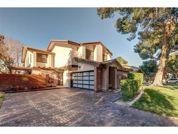 Beautiful two-story home with brick accents, modern garage door, and a well-maintained front yard at , Las Vegas, NV 89109