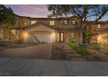 Charming two-story home featuring a well-manicured lawn, brick driveway, and inviting entrance at 1163 Highbury Grove St, Henderson, NV 89002