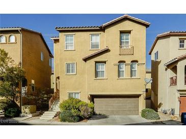 Tan three-story house with a two-car garage and landscaping at 1300 Sand Castle Ave, Las Vegas, NV 89183