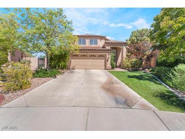 Charming two-story home featuring desert landscaping, a concrete driveway, and a two-car garage at 306 Treehouse Ct, Henderson, NV 89012