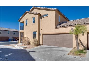 Two-story tan home featuring a two-car garage, a balcony, and desert landscaping at 4626 Lime Straight Dr, Las Vegas, NV 89115