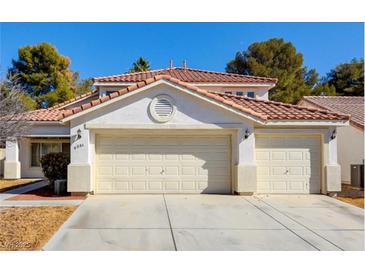 Charming two-story home featuring a three-car garage, tiled roof, and manicured landscaping at 6086 Shadow Oak Dr, North Las Vegas, NV 89031