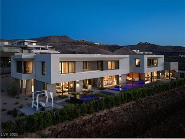 Stunning modern home featuring a sleek design and inviting outdoor space with a pool and mountain views at 709 Dragon Peak Dr, Henderson, NV 89012