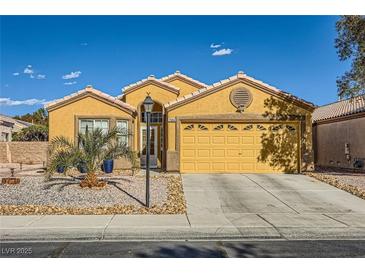 One-story house with a two-car garage and desert landscaping at 7666 Rainbow Cove Dr, Las Vegas, NV 89131