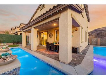 Inviting backyard with a sparkling pool, covered patio, and outdoor dining area perfect for entertaining at 864 Firestone Ledge Ave, Henderson, NV 89012