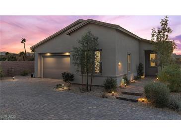 Charming single-story home with a well-manicured front yard and a two-car garage on a brick driveway at 91 Alta Cascata Pl, Henderson, NV 89011