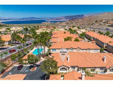 Stunning aerial view of the condos featuring a pool, mountains, and a glimpse of the lake at 107 Topsail Dr, Boulder City, NV 89005