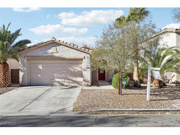 Charming single-story home featuring desert landscaping, a two-car garage, and mature palm trees at 10765 Muscari Way, Las Vegas, NV 89141