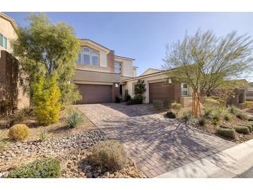 Beautiful two-story home featuring a well-manicured front yard and brick paved driveway at 12 Hilltop Crest St, Henderson, NV 89011