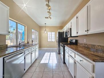 Bright kitchen features white cabinetry, stainless steel appliances, and natural light at 1851 Hillpointe Rd # 2124, Henderson, NV 89074