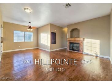 Spacious living room boasts gleaming hardwood floors, ceiling fan, and cozy fireplace at 1851 Hillpointe Rd # 2124, Henderson, NV 89074