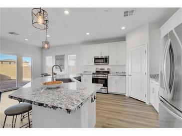 Bright, modern kitchen features granite countertops, stainless steel appliances, and wood flooring at 92 Starlight Sonata Ave, Henderson, NV 89015