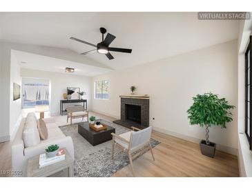 Bright living room featuring a fireplace, ceiling fan, and modern furniture at 353 Keating St, Henderson, NV 89074