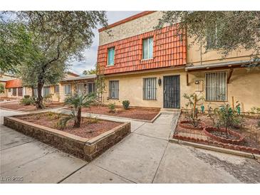 Charming townhouse featuring a welcoming facade with well-maintained landscaping and secure iron gate entrance at 3932 Voxna St, Las Vegas, NV 89119