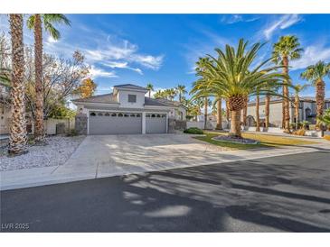 Charming single-story home featuring a three-car garage, desert landscaping and palm trees at 6005 Blowing Bellows St, Las Vegas, NV 89130