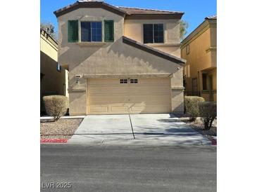 Two-story house with beige exterior, green shutters, and a two-car garage at 6460 Raven Hall St, North Las Vegas, NV 89084